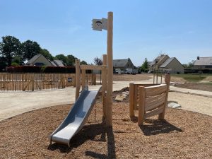 Structure de jeu en bois de robinier en forme de petit bateau.