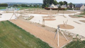 Aménagement d'une aire de jeux complète en bois de robinier avec diverses structures de jeu.